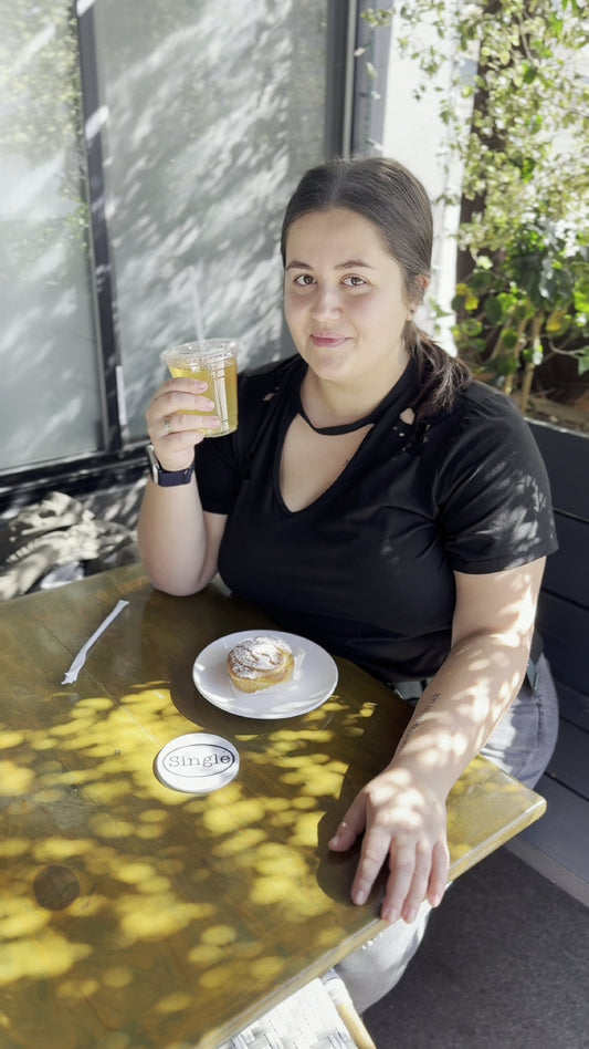 Angelina sits with her new Single® Drink Coaster.