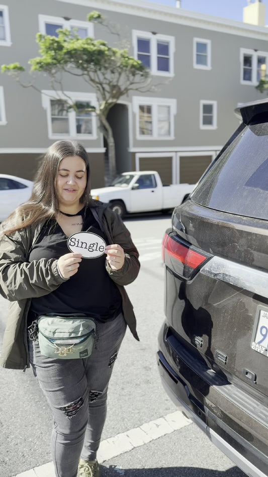 Angelina placing a Single® Large Sticker on her SUV.