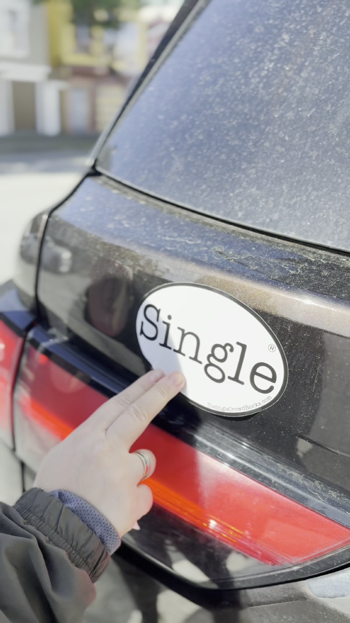 Angelina placing a Single® Large Sticker on her SUV.