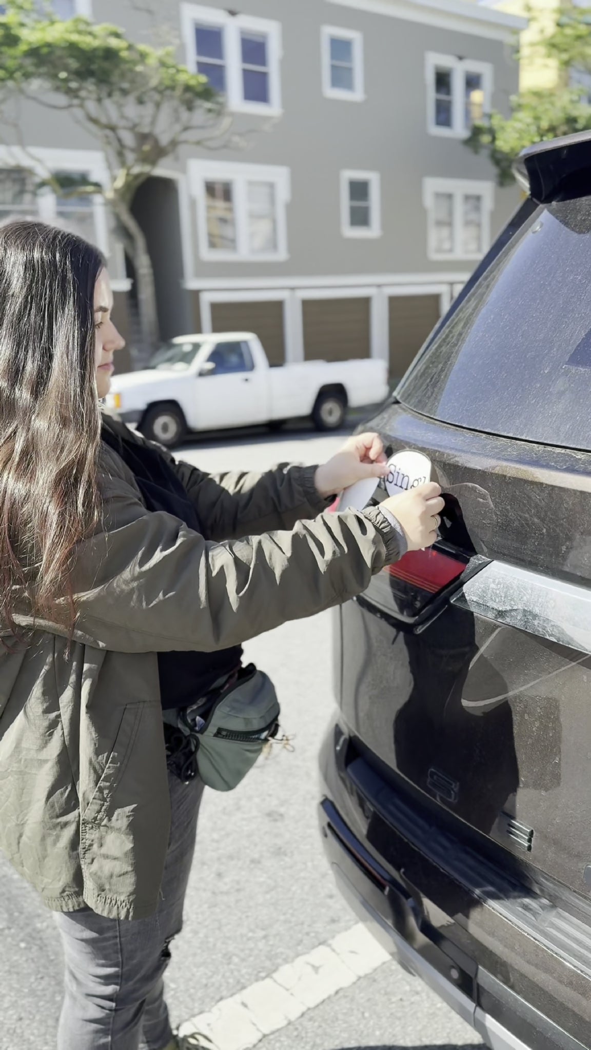 Angelina placing a Single® Large Sticker on her SUV.