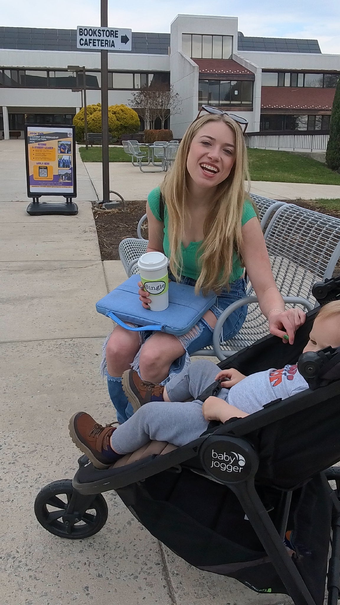 Cassidee waits for class holding her coffee mug with the Single® Medium Sticker applied to it.