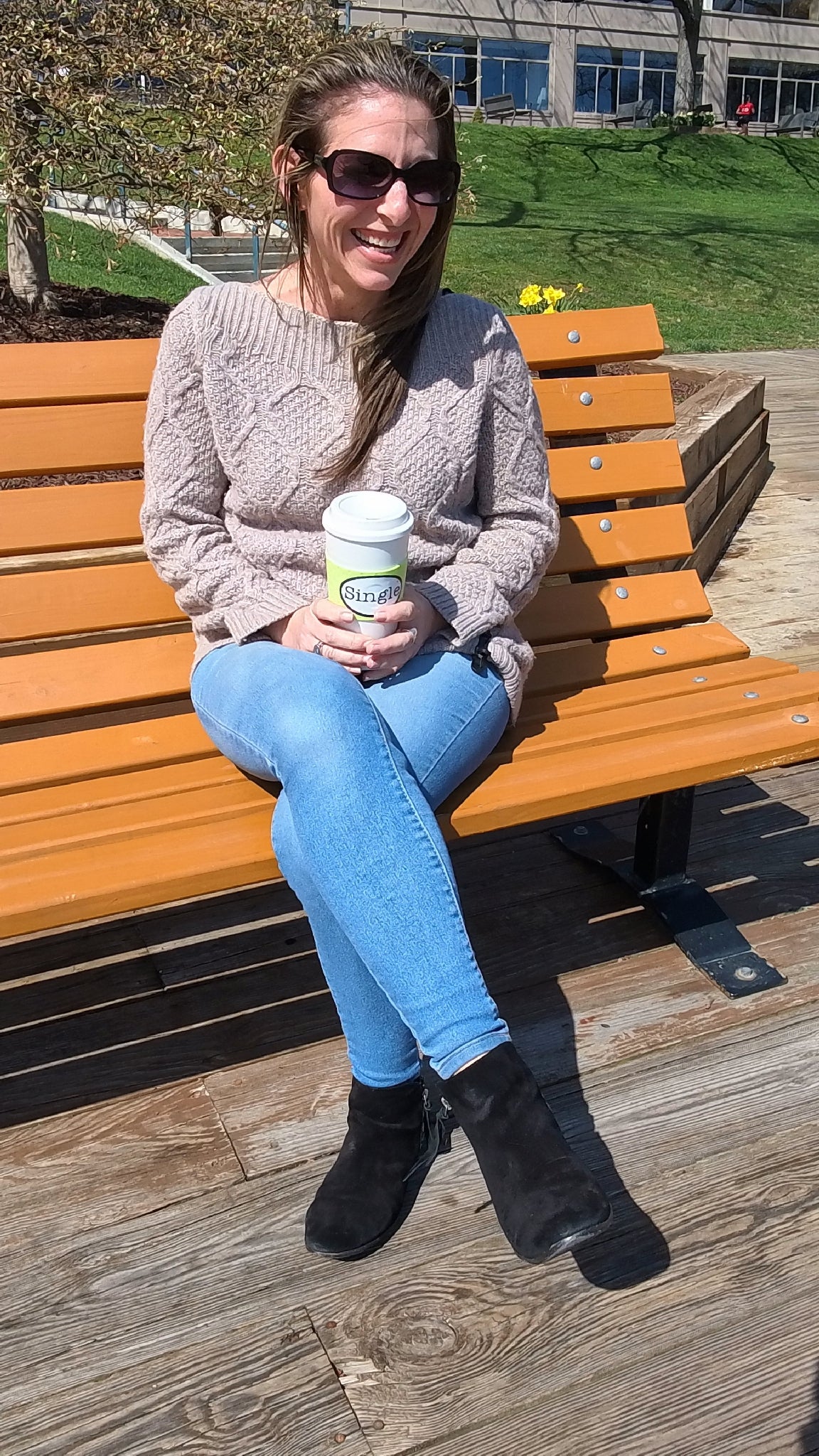 Jill laughs as an airplane interrupts the filming of her “Best First Date”, as she holds her coffee mug with the Single® Medium Sticker applied to it.