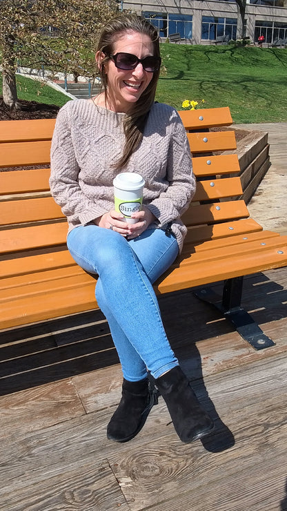 Jill laughs as an airplane interrupts the filming of her “Best First Date”, as she holds her coffee mug with the Single® Medium Sticker applied to it.