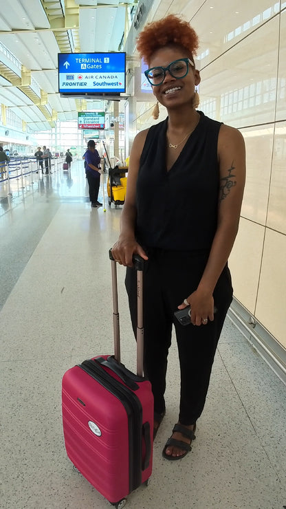 Kayla strolls through the airport with a Single® Medium Sticker on her luggage.