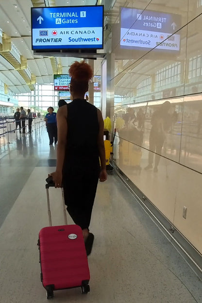 Frequent traveler Kayla strolls through the airport with a Single® Medium Sticker on her luggage.